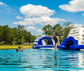 Island Oaks guests swimming in the lake near the inflatable obstacle course