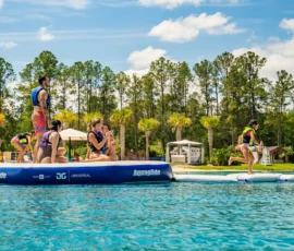 Adults cheering on a young girl running on the Island Oaks inflatable obstacle course