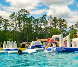 Man diving through an obstacle on the Swimming Lake inflatable course