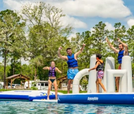 Couples standing on the inflatable obstacle course in the Island Oaks Swimming Lake