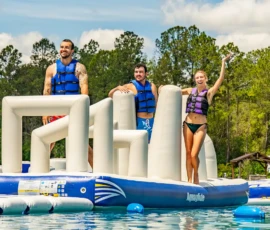 Island Oaks guests waving on the inflatable obstacle course in the Swimming Lake