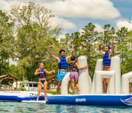 Couples on the inflatable obstacle course in the Island Oaks Swimming Lake
