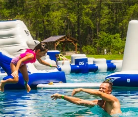 Father playfully tossing his daughter while both are swimming in the Island Oaks Swimming Lake