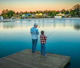 Father and son fishing on the dock of the lake at Island Oaks