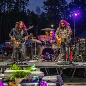 Live band performing at a nighttime outdoor event at Island Oaks