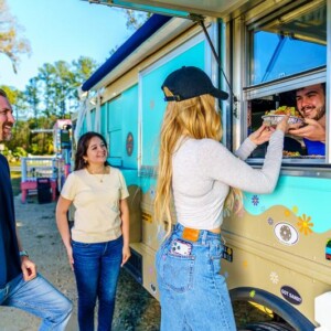 Salsa & Sizzle food truck serving a bowl to a group of customers