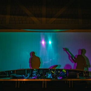 Silhouettes of a live band performing on the stage of the Island Oaks clubhouse