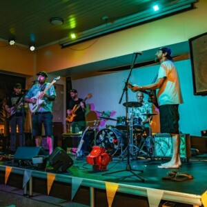 Live band performing on stage inside the Island Oaks clubhouse