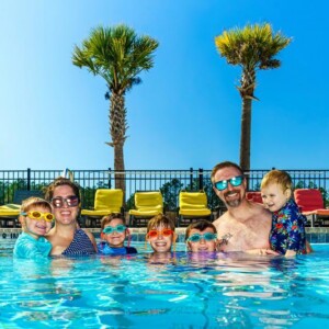 Happy family of mom, dad, and kids in the Island Oaks pool